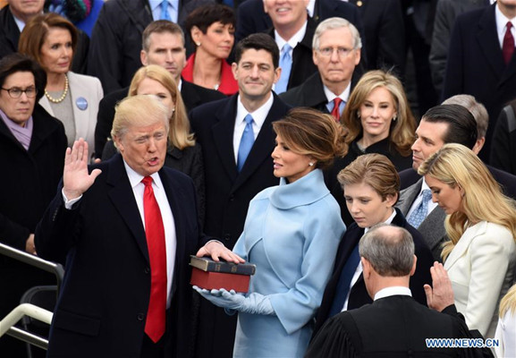 U.S. President Donald Trump(L) takes the oath of office during the presidential inauguration ceremony at the U.S. Capitol in Washington D.C., the United States, on Jan. 20, 2017. Donald Trump was sworn in on Friday as the 45th President of the United States. (Xinhua/Yin Bogu)