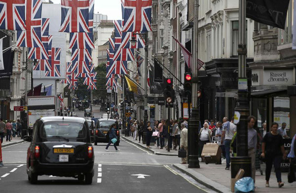Shoppers walk past stores on New Bond Street in London, on July 9, 2016. (Photo/Agencies)