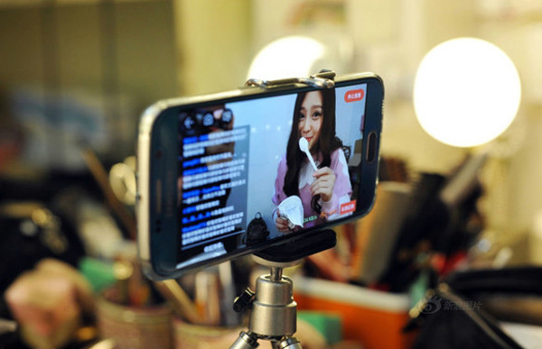An online anchor uses her mobile phone for live streaming. (Photo/Xinhua)
