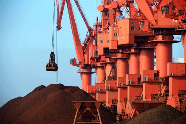 Iron ore is being unloaded at Qingdao port in Shandong province, July 7, 2014. (Photo provided to China Daily)