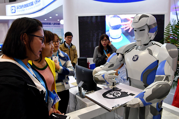 A robot paints a portrait for a visitor during the 2016 World Robot Conference in Beijing, Oct 20, 2016. (Photo/Xinhua(