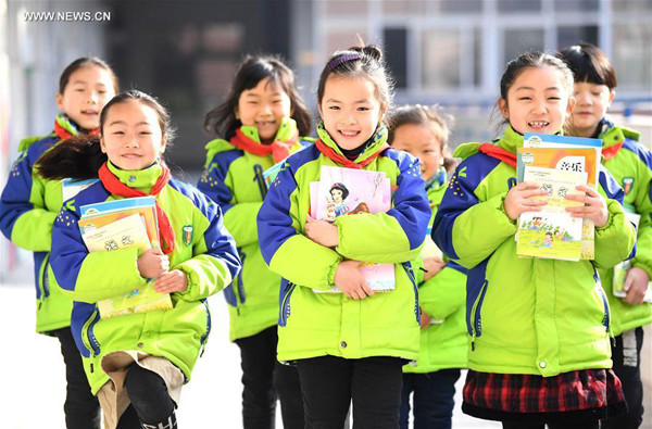 Students receive new books at Fenghua Primary School in Bozhou, East China's Anhui province, Feb 13, 2017. (Photo/Xinhua)