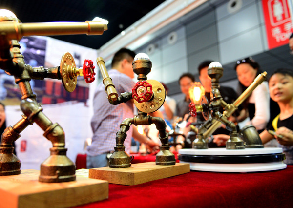Visitors watch displays made of used pipes and valves at a creative industry expo in Luoyang, Henan province, May 21, 2016. (Photo/Xinhua)