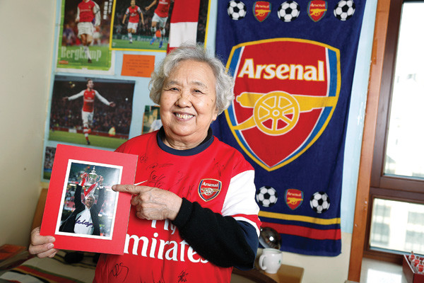 Granny Liu Hongwen poses with memorabilia wearing her Arsenal shirt. (China Daily)