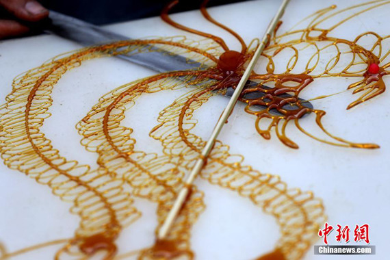 Sugar drawing, a traditional Chinese folk art uses hot caramel to create two-dimensional figures. (File photo/Chinanews.com)