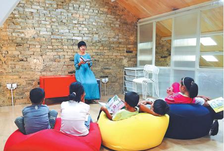 Huang Juan tells the story of The Little Prince to the pupils in the village. (Photo: China Daily/Lin Aihua)