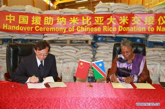 Chinese Deputy Foreign Minister Zhang Ming (L) and Namibian Deputy Prime Minister and Minister of International Relations and Cooperation Netumbo Nandi-Ndaitwah sign documents at a handover ceremony of Chinese rice in Windhoek, Namibia, on April 4, 2017. (Xinhua/Wu Changwei)