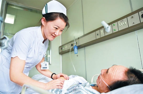A nurse at the China-Japan Friendship Hospital cares for an inpatient. (Photo/Feng Yongbin)