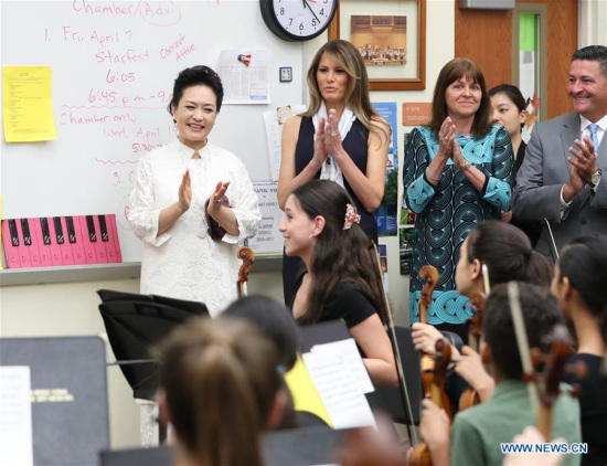 Peng Liyuan (1st L), wife of Chinese President Xi Jinping, and U.S. First Lady Melania Trump (2nd L), applaud to a performance by students during their visit to the Bak Middle School of the Arts in West Palm Beach, Florida, the United States, April 7, 2017. (Xinhua/Wang Ye)