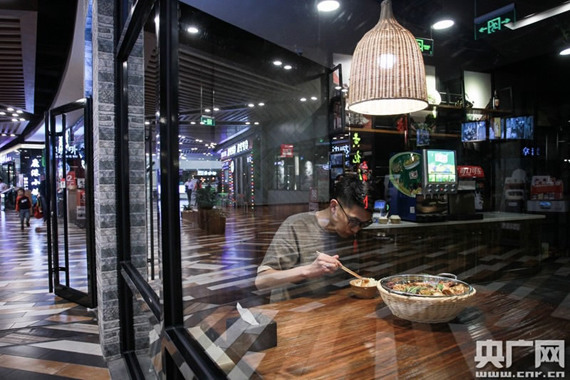 A young man enjoys his dinner for one in Beijing.  (Photo/CNR)