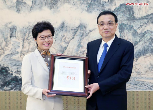 Chinese Premier Li Keqiang (R) grants the official certificate of appointment to Lam Cheng Yuet-ngor as the fifth-term chief executive of Hong Kong Special Administrative Region in Beijing, capital of China, April 11, 2017. (Xinhua/Yao Dawei)