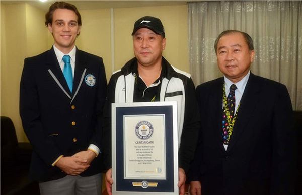 Li Yongbo(C) receives recognition from Guinness World Records representatives for winning the most Sudirman Cups, Oct 29, 2015. (Photo/ Guinness World Records Weibo)