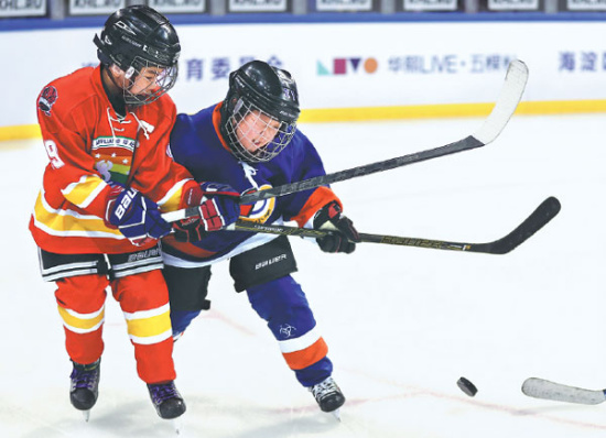 Payers from the Elementary School Affiliated to Renmin University (red) and Zhongguancun No 1 Primary School compete in an exhibition game at Wukesong Arena following the March 19 opening ceremony for the 2017 Haidian District School Hockey League season. Provided to China Daily