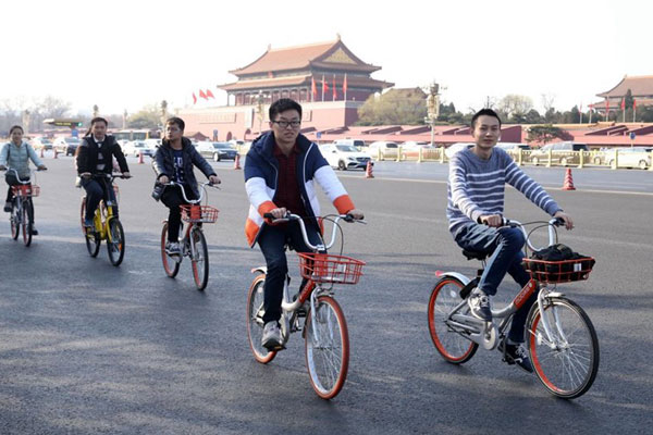 People ride shared bikes along the Chang'an Avenue of Beijing on March 10, 2017. (Photo/People's Daily Online)