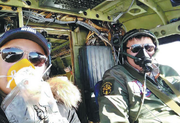 Zhang Xinyu (right) pilots a Y-12 aircraft across the Atlantic Ocean from Fortaleza, Brazil, to Playa, Cape Verde, along with Liang Hong, his wife. They wear oxygen masks to deal with altitude sickness. Photo Provided To China Daily