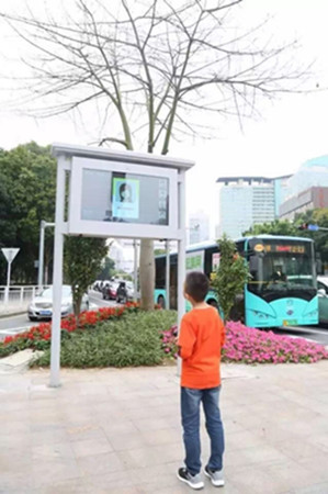 The LED screen shows the virtual portrait of a female jaywalker. (Photo/Shenzhen Evening News)