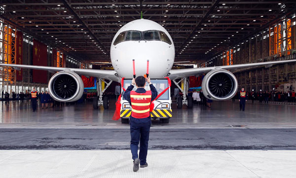 A C919 aircraft rolls off the assembly line in Shanghai. The plane, China's homegrown big passenger jet, completed its first high-speed taxiing test on Sunday. (Photo by Yin Liqin/For China Daily)