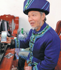 Yang Shaochen conducts a consultation via his smartphone. (Photo by Yang Jun/China Daily)
