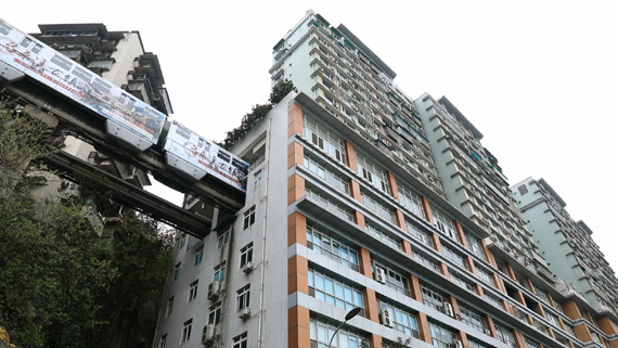 A light rail passenger train runs through a 19-storey residential block. (Photo/CGTN)