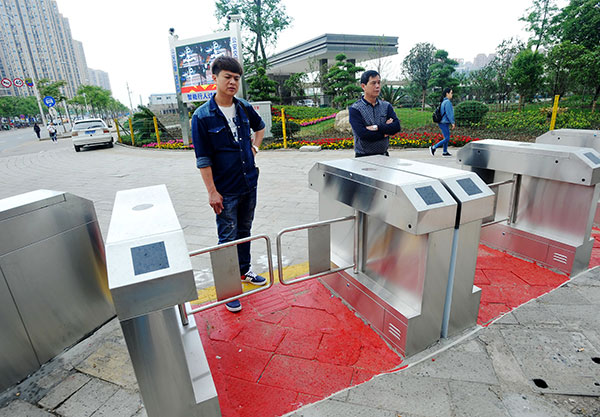Pedestrians wait at closed turnstiles at a street crossing in Wuhan, Hubei province, on Wednesday.Miao Jian / For China Daily