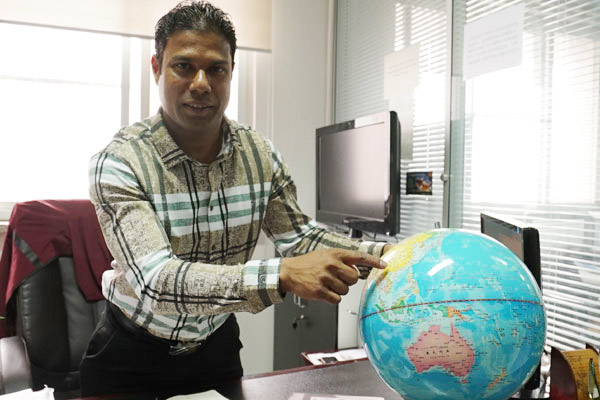 Anura Banda, CEO of Beijing Heavenly Trade Co Ltd, points at a globe showing the 'Tea Road' from Sri Lanka to China at his office in Beijing, China, on April 19, 2017. (Photo by Li Xiupeng / chinadaily.com.cn)