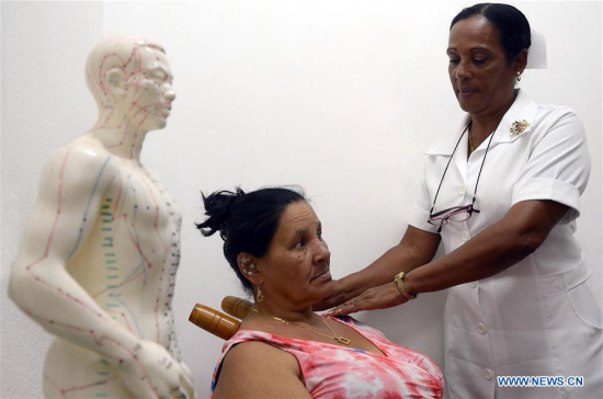 Image taken on March 2, 2017 shows a nurse applying a natural and traditional Chinese medicine treatment on a patient at the Camilo Cienfuegos primary care center in Havana, Cuba.  (Xinhua/Joaquin Hernandez)