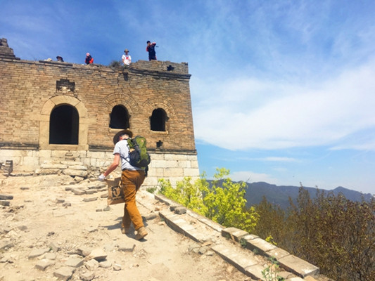 William Lindesay is collecting garbage at the Jiankou section of the Great Wall during a cleanup event held on April 22. [Photo by Guan Weiwei/China.org.cn]