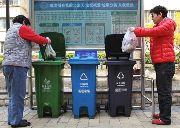 People dispose of trash in Beijing's Fengrongyuan residential community. (Photo by Zhang Wei/China Daily)