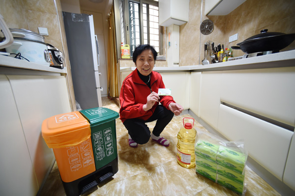 A resident of Xiamen, Fujian province, displays a credit coupon she received for sorting her household trash. The coupon can be exchanged for household items. (Photo/Xinhua)