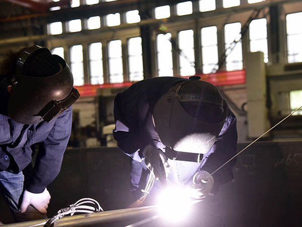 Huang (R) welds a piece of product while her trainee Zhang Yin looks on, April 25, 2017. (Photo by Song Wei/chinadaily.com.cn)