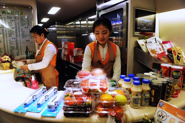 Workers sort out food and beverage products on a high-speed train from Qingdao to Chongqing in January.(Yu Fangping / For China Daily)