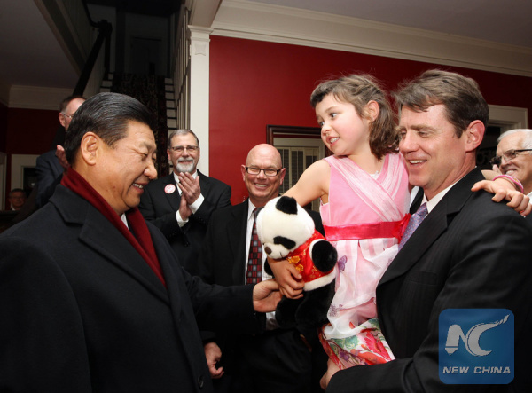 Photo taken on Feb. 15, 2012 shows Xi Jinping (L), then Chinese Vice President, presents the granddaughter of his old friend Sarah Lande with a panda doll in Muscatine, Iowa, the United States. (Xinhua/Lan Hongguang)