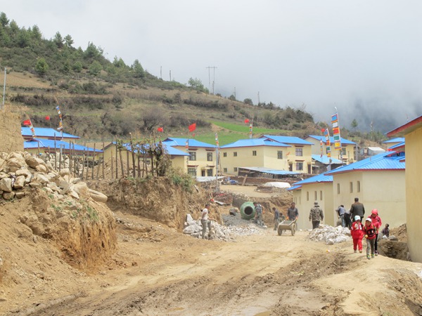 A view of newly constructed houses and an eight-kilometer-long under-construction road in the Ta village of Gyirong county, Tibet autonomous region. (Photo by Palden Nyima/chinadaily.com.cn)