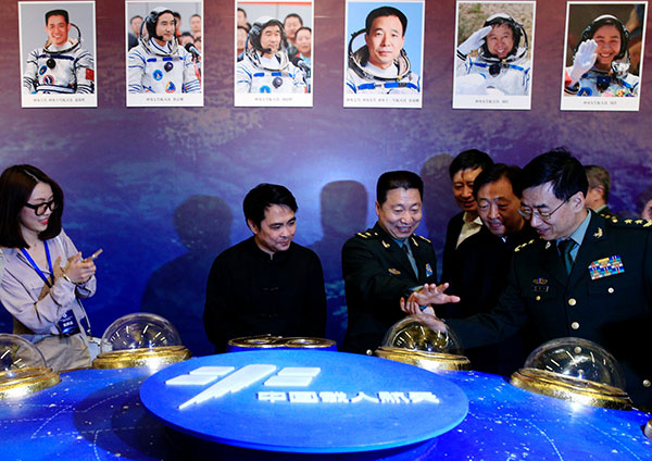 China's first man in space, Yang Liwei, compares his hand with his preserved print displayed at an exhibit about China Space Day at the National Museum of China in Beijing. JIANG DONG/CHINA DAILY