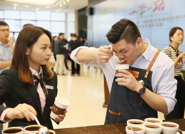 A barista shows how to taste coffee at the coffee trade center in Chongqing. (Photo/Xinhua)