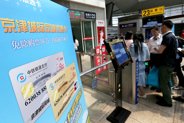 Passengers using commuter passes get aboard a train bound for Tianjin at Beijing South Railway Station on Sunday. (Photo by Wang Zhuangfei / China Daily)