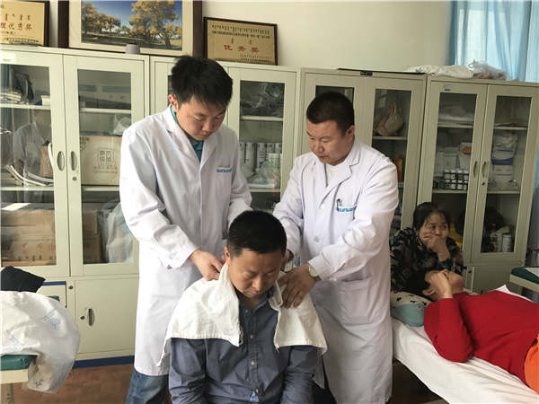 Namdaq Dampilon (left), a Russian intern, studies at the Inner Mongolia International Mongolian Hospital in Hohhot. YUAN HUI/CHINA DAILY
