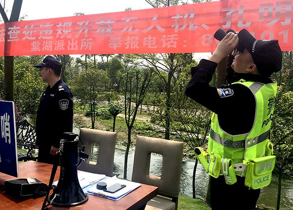 Police officers monitor the sky for drones that might interfere with aircraft at a checkpoint near Chengdu Shuangliu International Airport, in Chengdu, Sichuan province, on Saturday.Li Zhi / For China Daily
