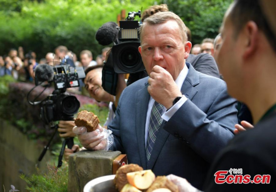 Danish Prime Minister Lars Loekke Rasmussen samples a snack before feeding a giant panda at the Chengdu Research Base for Giant Panda Breeding in Chengdu City, the capital of Southwest China’s Sichuan Province, May 2, 2017. Loekke Rasmussen is making his first visit to China since becoming prime minister. (Photo: China News Service/Liu Zhongjun)