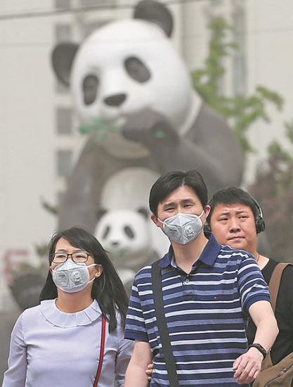 Many people in the Wangjing area of Beijing don masks on Thursday, following health officials' recommendations.