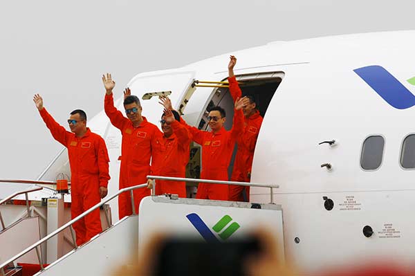 Crew members of the C919, China's first homegrown large passenger plane, wave at spectators in Shanghai on Friday after the plane completed its first test flight. (Photo/Xinhua)