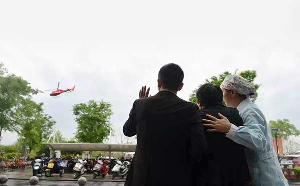 Liu Guoqun's father, Liu Wanyong (center), and other family members bid farewell to the helicopter carrying the woman's donated organs from Jiaxing to Hangzhou, Zhejiang province, on Thursday. It was the first step in a transplant relay. (Photo/CHINA DAIL)