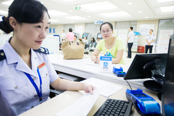 A citizen pays her taxes via Alipay, a mobile payment app developed by Ant Financial Services Group, the financial arm of Alibaba Group Holding Ltd, at the Xihu branch of Hangzhou Taxation Bureau in Zhejiang province, the first in China to adopt mobile payments in civic services. XU KANGPING / FOR CHINA DAILY