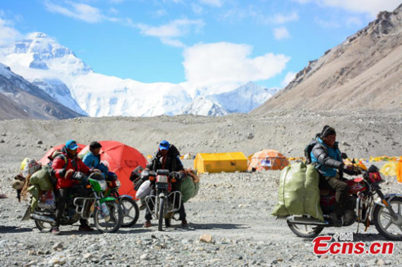 Volunteers transport bags of waste with their motorcycles in a cleaning campaign on the north slope of Mount Qomolangma in Southwest China's Tibet Autonomous Region, May 10, 2017.  (Photo: China News Service/Chen Taobin)