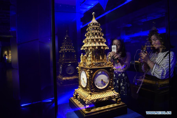 Visitors take photos of a clock on an exhibition of The Forbidden City and the Maritime Silk Road in the Palace Museum in Beijing, capital of China, May 8, 2017. A total of 140 sets of relics were on display on the exhibition. (Xinhua/Jin Liangkuai)
