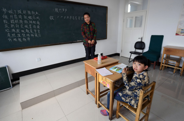  Tu Jiaqi, the only student in her school, has a Chinese lesson with her teacher, Tao Fengju. (Photo by LIU YANG/CHINA DAILY)