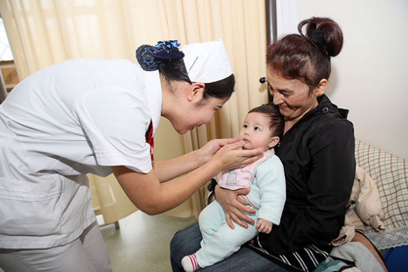 A nurse from the Hospital of Xinjiang Traditional Uyghur Medicine, attends to a mother from Uzbekistan, along with her daughter, who was born in the facility in Urumqi, capital of the Xinjiang Uygur autonomous region.(Photo/Xinhua)