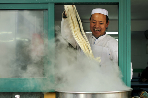 A lamian restaurant owner from Xining, Qinghai province, works in his business in Ningbo, Zhejiang province. (Hu Xuejun / Xinhua)