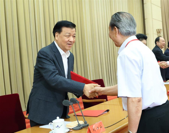 Liu Yunshan, a member of the Standing Committee of the Political Bureau of the Communist Party of China (CPC) Central Committee, awards a certificate to an author whose work is collected in national achievements library of philosophy and social sciences during a symposium on the formation of philosophy and social sciences with Chinese characteristics in Beijing, capital of China, May 17, 2017. (Xinhua/Wang Ye)