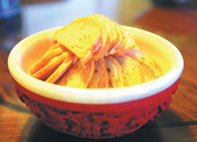 Smoky-flavored abalone roll, mixed with fish and chicken skin. (Photo by Xing Yi/China Daily)